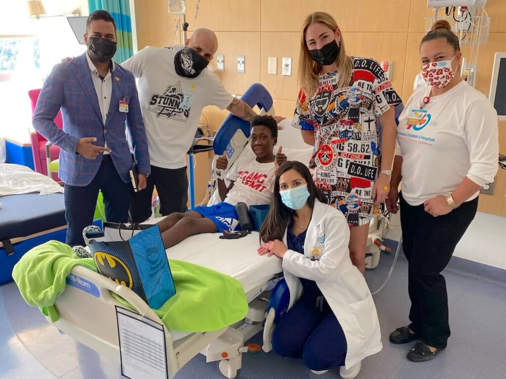 4 adults and a doctor visiting a child in a hospital